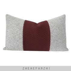 a red and white pillow sitting on top of a bed