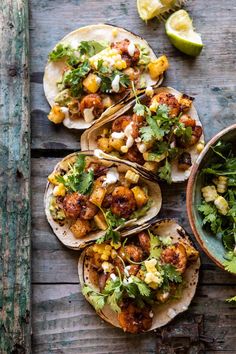 four tacos with chicken, corn and cilantro garnish on top