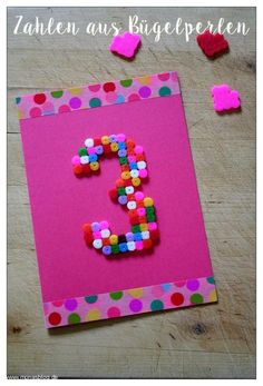 a pink card with the number five made out of confetti