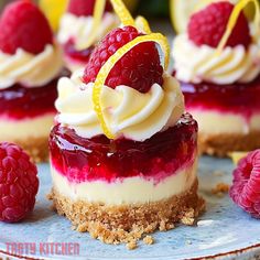 raspberry cheesecake topped with whipped cream and lemon wedges