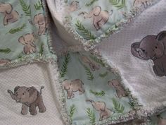 an elephant and giraffe print baby blanket on top of a bedding set