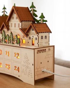 a wooden calendar with houses and trees on it