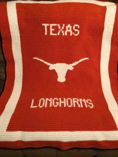 a crocheted texas longhorns blanket with the word texas on it