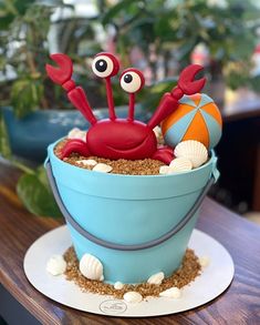 there is a cake shaped like a crab in a bucket on top of a table