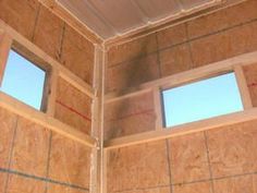 an unfinished bathroom with three windows in the wall and no curtains on the ceiling,