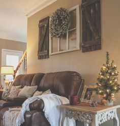 a living room filled with furniture and a christmas tree on top of a coffee table