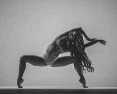 a black and white photo of a woman in a yoga pose with her legs spread out