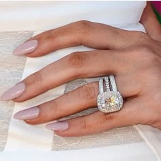 a close up of a person's hand with a ring on her finger and dress