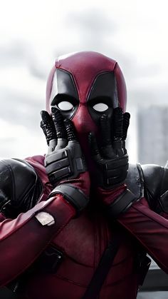 the deadpool is holding his hands up to his face