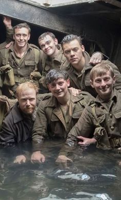 the men are posing for a photo in the water