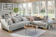 a living room filled with furniture and lots of windows