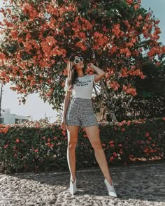 a woman standing in front of a tree