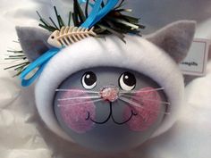 a close up of a cat ornament with scissors on it's head