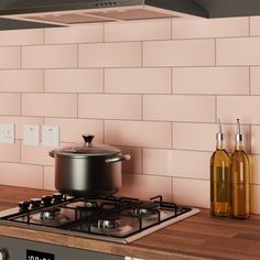 a stove top with a pot on it next to bottles and a bottle of oil