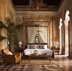 a bedroom with a canopy bed sitting next to a chair and table in front of it