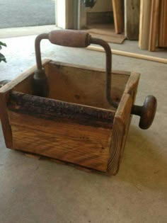 an old wooden box with handles on the floor