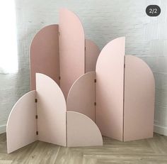 a pink room divider sitting on top of a hard wood floor