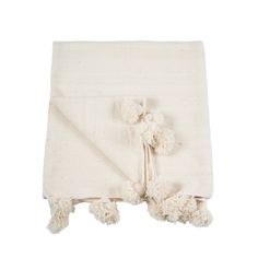 a white blanket with pom poms on it