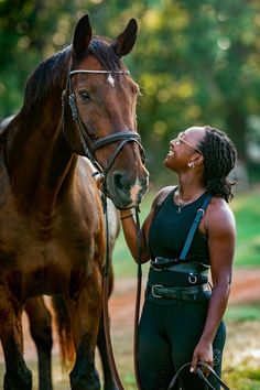 a woman standing next to a brown horse