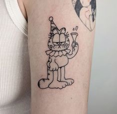 a person with a cat tattoo on their arm, holding a wine glass in one hand