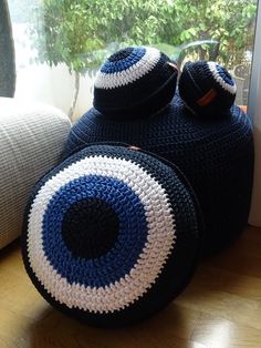 a blue and white crocheted bag sitting on top of a wooden floor next to a window