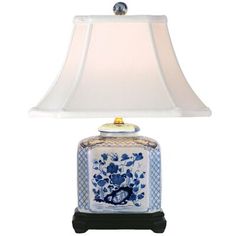 a blue and white vase lamp with a shade on it