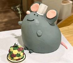 there is a cake shaped like a mouse and a small flower on the table next to it