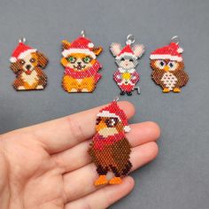 a hand holding a beaded christmas ornament with five different designs on it