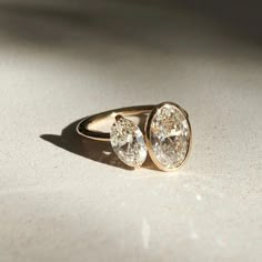 two diamond rings sitting on top of a table