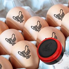 several brown eggs in an egg carton with black hen decals on the side