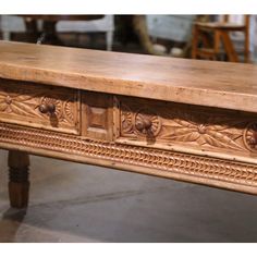 an old wooden table with carvings on it