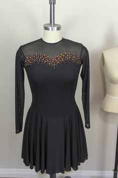 a woman's black dress with colorful beading on the neckline and long sleeves