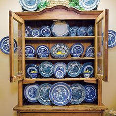 blue and white china cabinet with plates on it