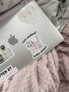 an open laptop computer sitting on top of a pink blanket