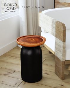 a wooden table sitting on top of a hard wood floor next to a bath tub