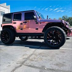 a pink jeep parked in a parking lot