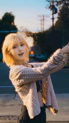 a young woman is taking a selfie with her cell phone while standing on the street