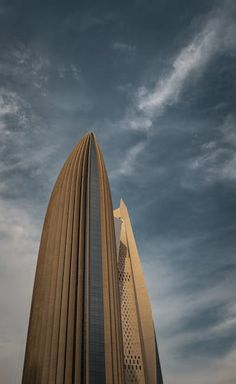 a very tall building sitting under a cloudy sky