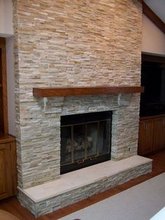 a living room with a stone fireplace and entertainment center