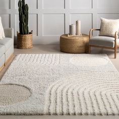 a living room with two couches and a rug on the floor in front of a wall