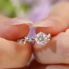 a person holding a diamond ring in their hands