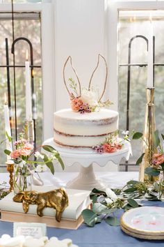 a white cake sitting on top of a table next to other desserts and decorations