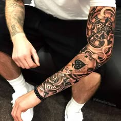 a man sitting down with a tattoo on his arm