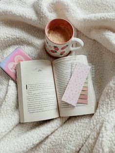 an open book and cup of coffee on a bed