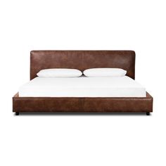 a brown leather bed frame with white pillows