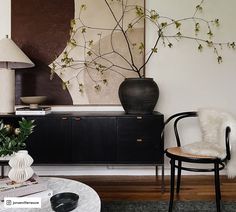 a black and white living room with a painting on the wall, chair and table