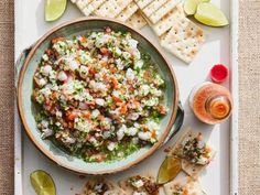 a platter with crackers, salsa and tortilla chips on the side