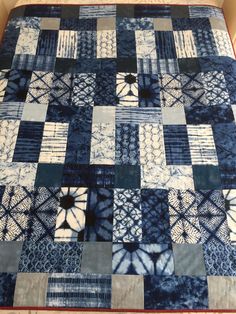 a blue and white quilt on top of a bed