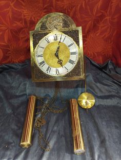 an antique clock with roman numerals on the face and chain attached to it