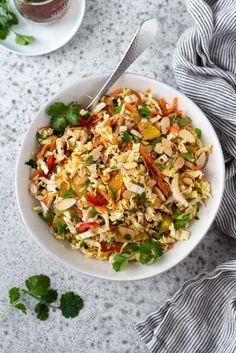 a white bowl filled with rice and veggies next to a cup of tea